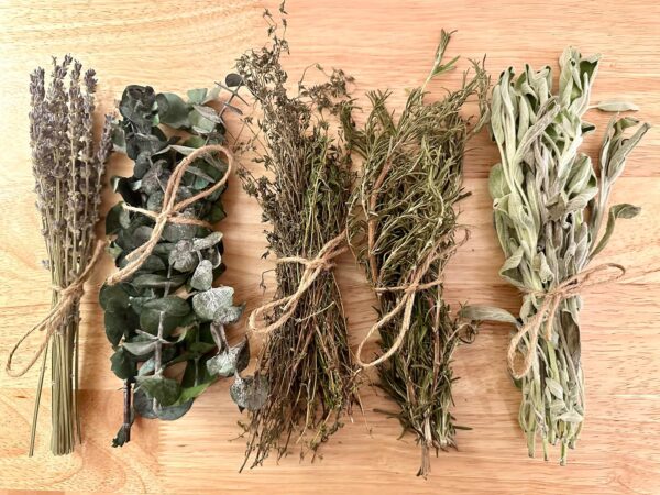 bunches of tied herbs and lavender on a wood table