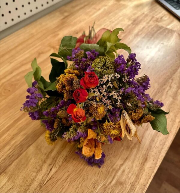 close up of rustic dried flower bouquet of mixed flowers on a wood table