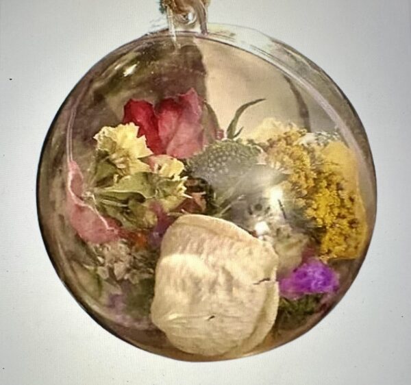 a close up of a ball ornament filled with dried flowers