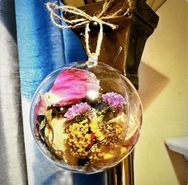a close up of a ball ornament with rose petals and flower heads
